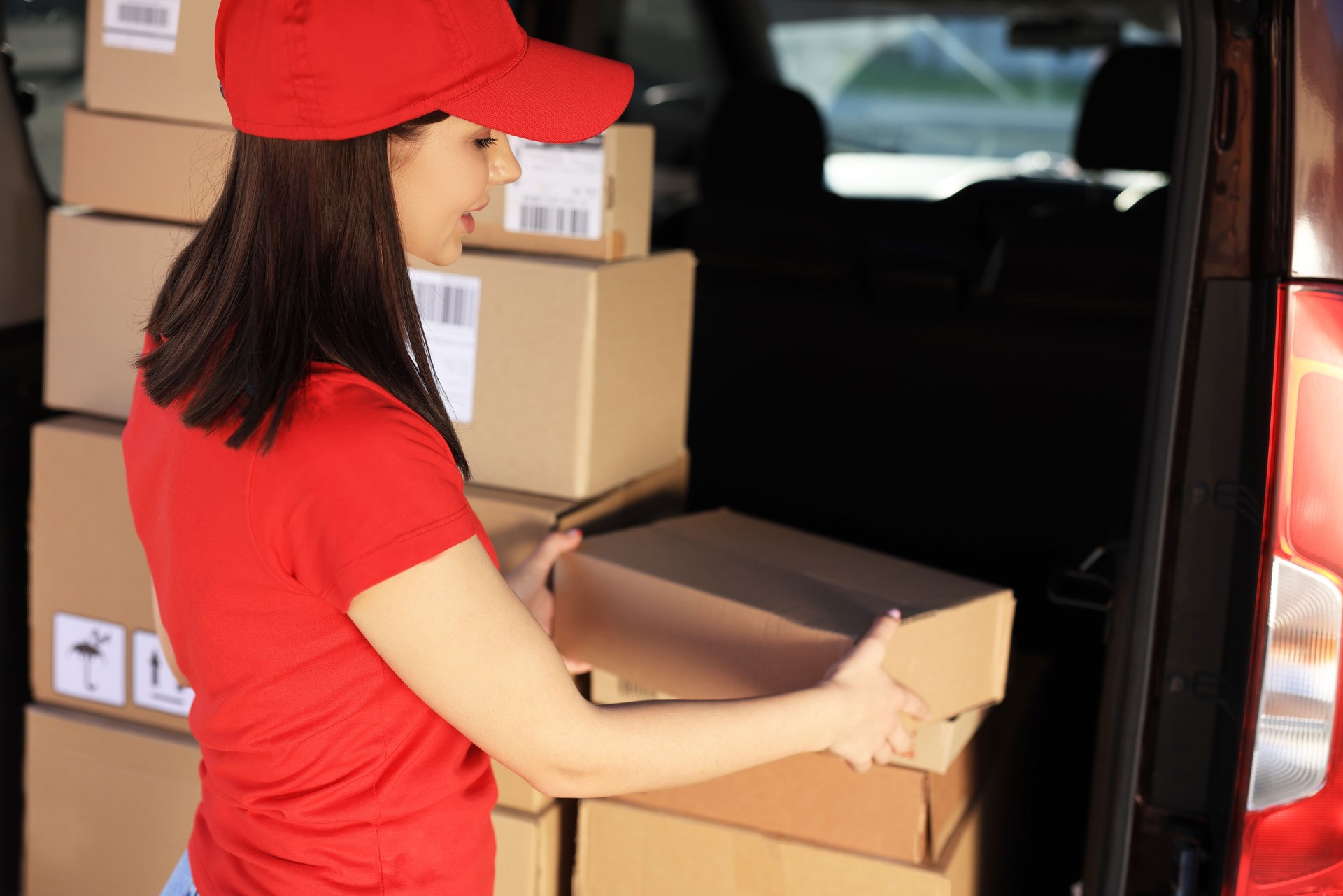 Courier taking parcel from delivery van outdoors