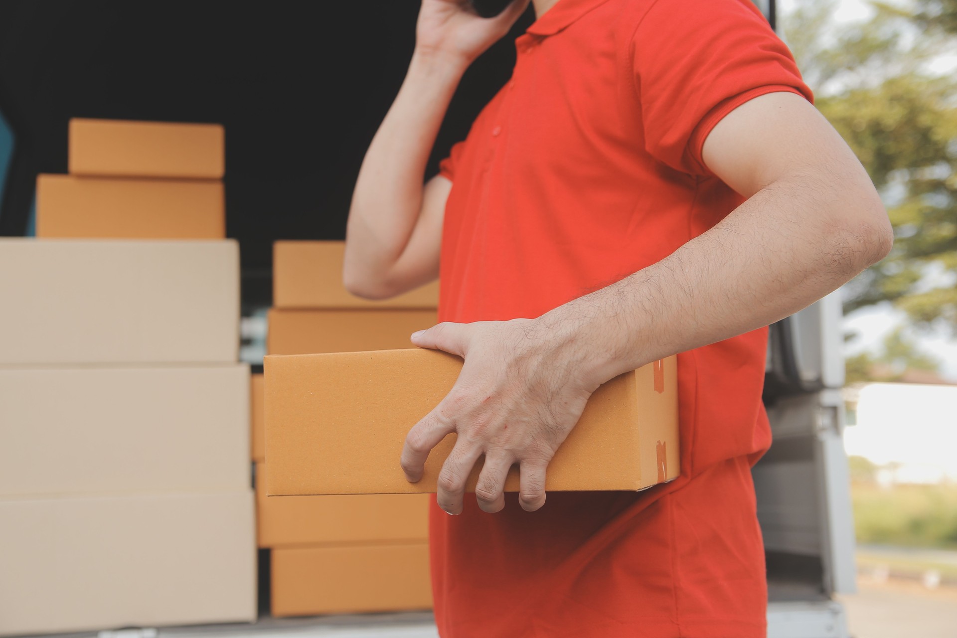 Asian delivery express courier young man use giving boxes to woman customer he wearing protective face mask at front home